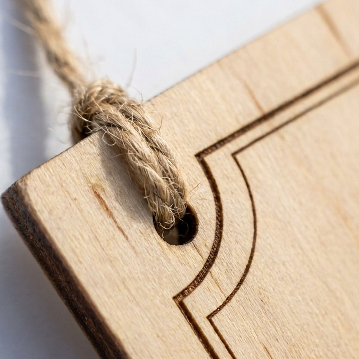 Detail of the laser-cut hole threaded with natural jute twine