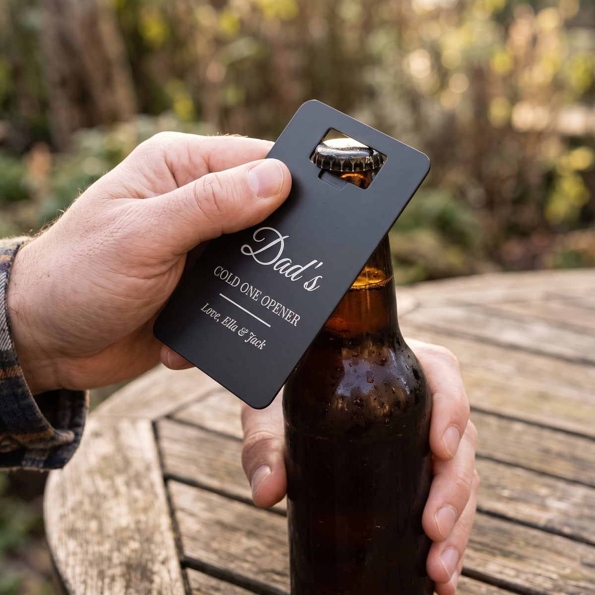 Man opening a beer with a personalised card bottle opener