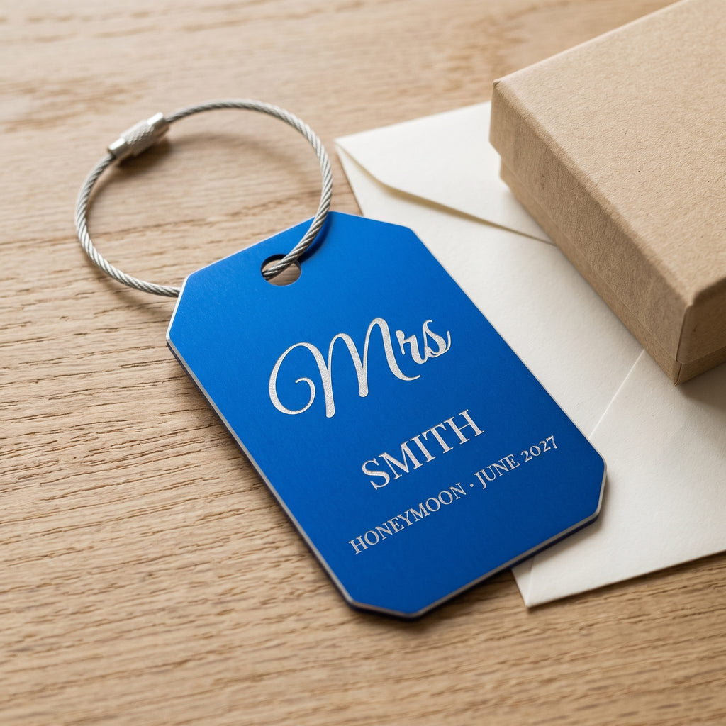 Engraved blue Mrs Smith luggage tag on light oak