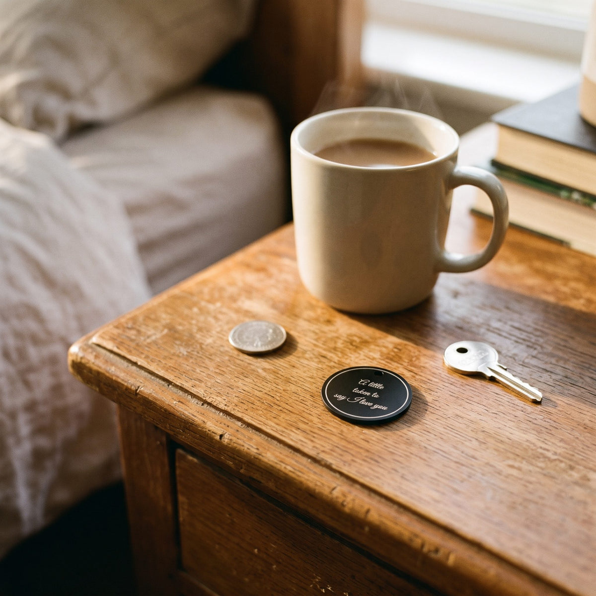 Pocket token on a bedside table beside a mug of tea