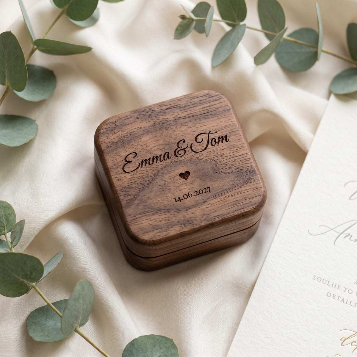 Engraved walnut ring box on cream silk with eucalyptus