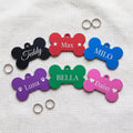 Six personalised bone pet tags in black, red, blue, purple, green and pink, each engraved with a pet name
