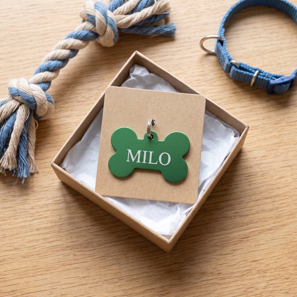 Green bone pet tag engraved MILO on a kraft gift card in a gift box for a new puppy