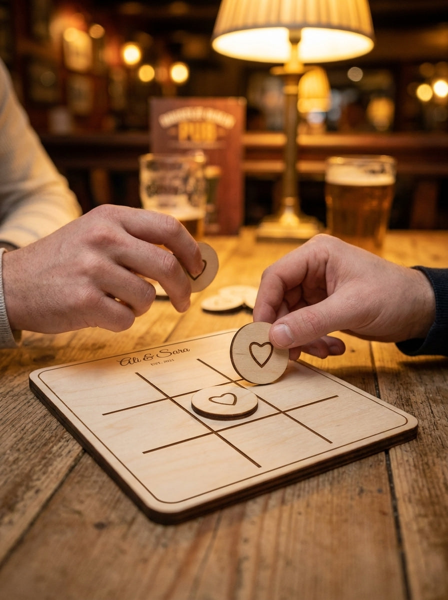 Personalised noughts & crosses set with heart counters being placed in a cosy pub